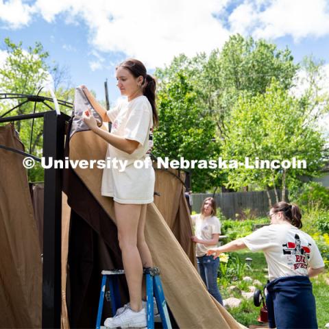 Alyssa Dunlap of Tri Delta attaches the outer curtain of a pergola during the Big Event. May 4, 2024. Photo by Kirk Rangel for University Communication.